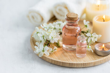 Obraz na płótnie Canvas Natural fresh perfume with the scent of apple tree blooming flower on wooden bamboo tray. Aromatherapy, wellness, luxury perfumery concept. Organic ingredients for toilet water and essential oils