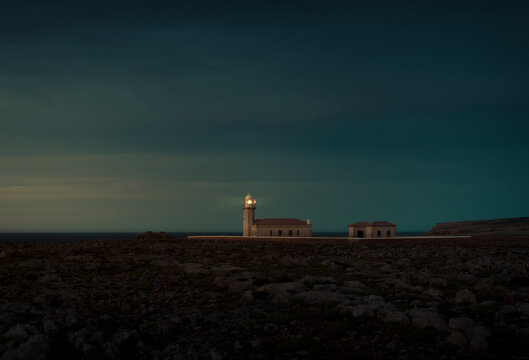 Cinematic lighthouse during dramatic dark sunset
