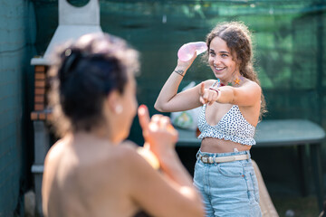 mother and daughter playing water balloon tossing in the garden