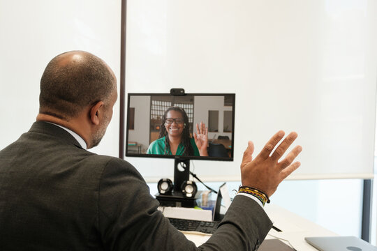 Businesspeople greeting each other on video call 