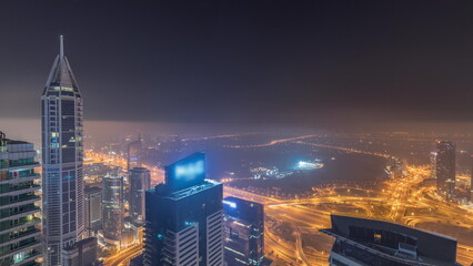 Obraz premium Aerial skyline with Golf Club, hotels and residential areas far away in desert in Dubai all night timelapse, UAE, top view