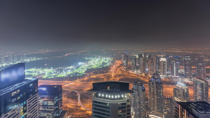 Panorama of Dubai Marina with JLT skyscrapers and golf course night timelapse, Dubai, United Arab...