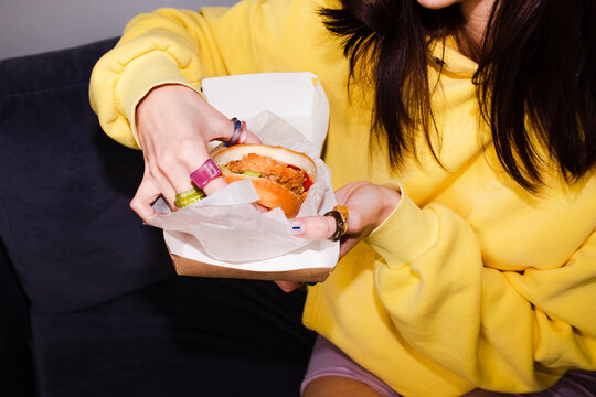 Showing fast food sandwich in hands 