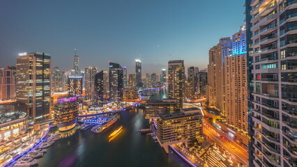 Fototapeta na wymiar Aerial view to Dubai marina skyscrapers around canal with floating boats day to night timelapse