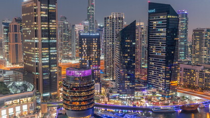 Dubai Marina Skyline with JLT district skyscrapers on a background aerial day to night timelapse.