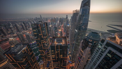 Obraz premium Skyline sunset view of Dubai Marina showing canal surrounded by skyscrapers along shoreline day to night timelapse. DUBAI, UAE