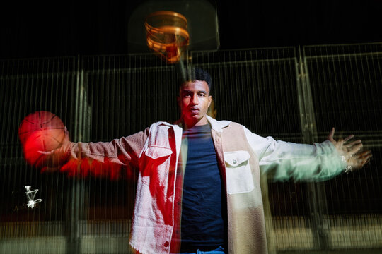 Man with open arms holding basketball ball.