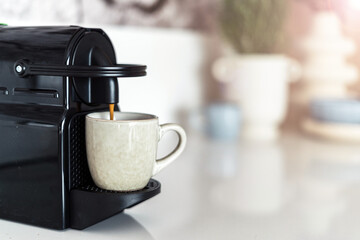 Modern coffee machine filling a ceramic cup with espresso