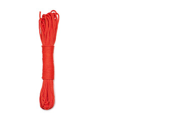Bundle of neatly twisted red nylon rope on a white background. Red rope on a white background. Tool for economic activities in the form of a red rope. Free space for text