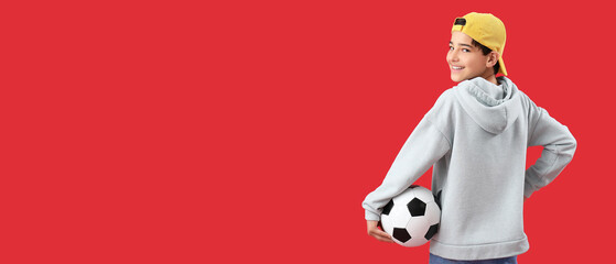 Little boy holding soccer ball on red background with space for text