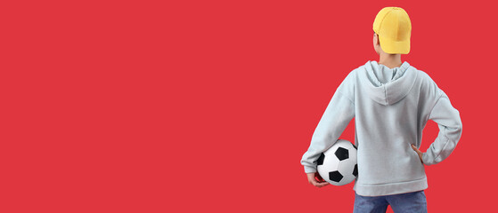 Little boy holding soccer ball on red background with space for text, back view