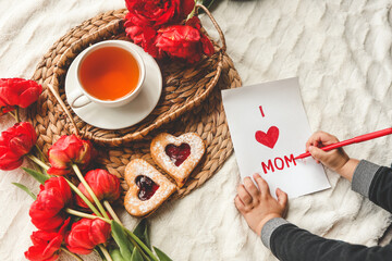 The child draws a card for mother's day for mom, a festive concert