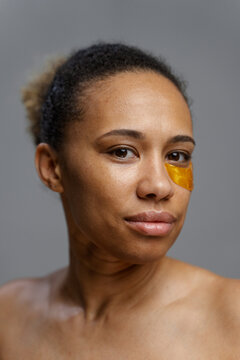 A woman with a patch under her eye looks at the camera