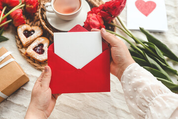 Woman's hands holding a letter in craft envelope. Mother's Day or Valentine's Day concept. Place for your text