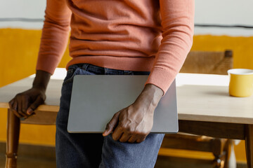 A man holds a laptop in his hands