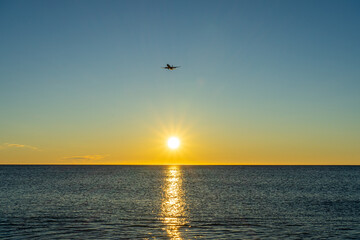 Airplane landing at sunrise over Mediterranean Sea, Costa del Sol in Malaga, Spain 
