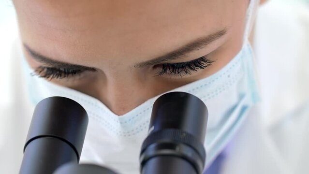 Doctor, covid or scientist woman with microscope in science lab for DNA research, medical and medicine data analysis. Zoom, analytics and nurse for healthcare, cancer innovation or virus test in lab - Powered by Adobe