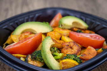To go order of grilled shrimp and veggies are packed fresh in plastic container for take out