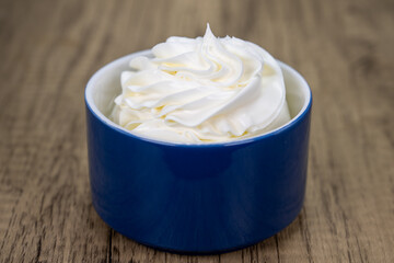 Side order of a swirled top portion of sour cream served in a decorative bowl