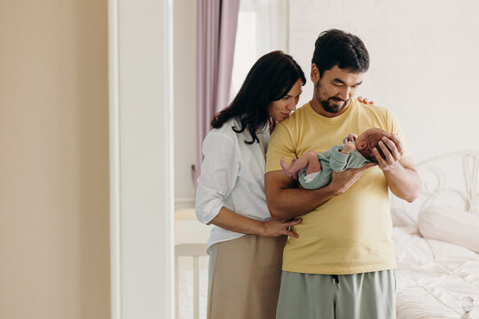 Happy multiracial family and their newborn baby