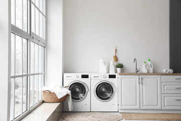 Interior of laundry room with washing machines and dirty clothes - obrazy, fototapety, plakaty