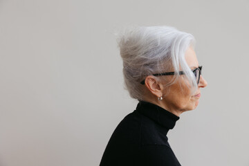 Woman in simple studio with serious expression.