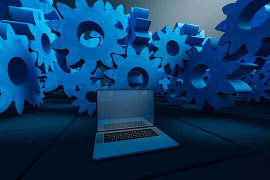 Laptop computer next to cogwheel gears