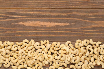 Heap of tasty cashew nuts on wooden background