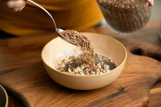Making muesli oats breakfast with nut milk. Adding flaxseed. 