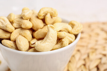 Bowl with tasty cashew nuts on table, closeup