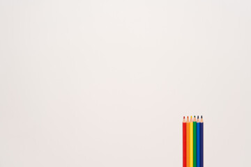 Pencils with rainbow pride colors on the back with copy space and white background