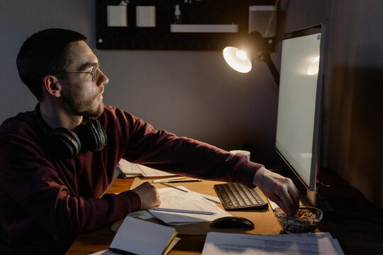 A man uses a computer while working at night
