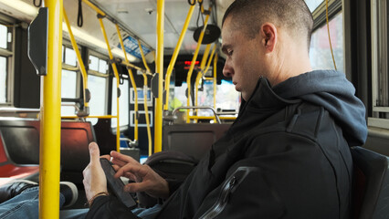 Commuter checking Phone While Riding a City Bus