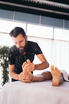 Massage therapist treating a woman's feet