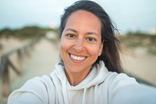 ugc selfie of tanned young woman on the beach at sunset