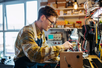 Focused young man is working in repair workshop