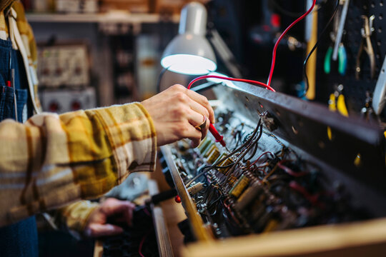 Anonymous man repairing amplifier in workshop