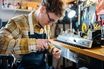 Handy man applying lubricant spray on detail of amplifier