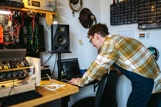 Repairman with laptop checking sound of amplifier
