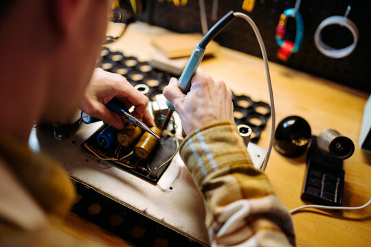Crop master repairing capacitors at workbench