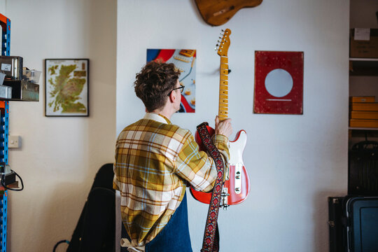 Repairman with electric guitar in garage