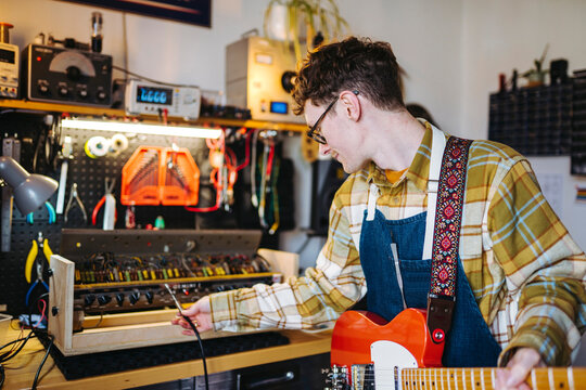 Repairman with cable of electric guitar