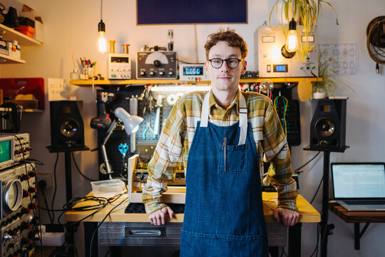 Enterprising man standing in own repair shop