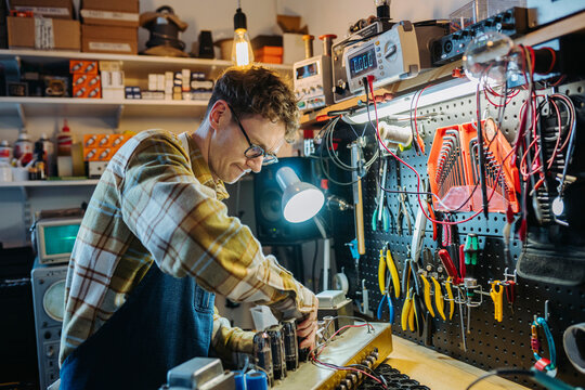 Young master working in repair shop with various tools