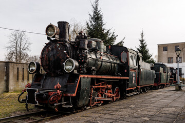 Fototapeta premium Vintage locomotive, steam train in an outdoor depot.