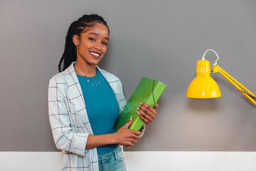 Cheerful black woman with green folder