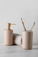 Holder of bamboo toothbrushes and bath accessories on white table