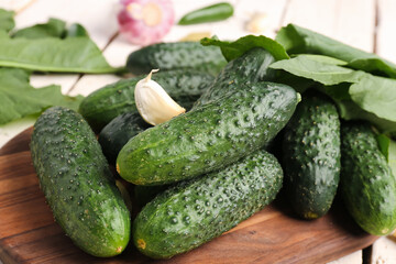 Board with fresh cucumbers for preservation on table, closeup