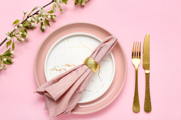 Beautiful table setting with blooming tree branch on pink background