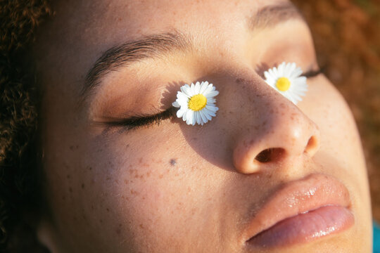 Woman with daisies on her eyes